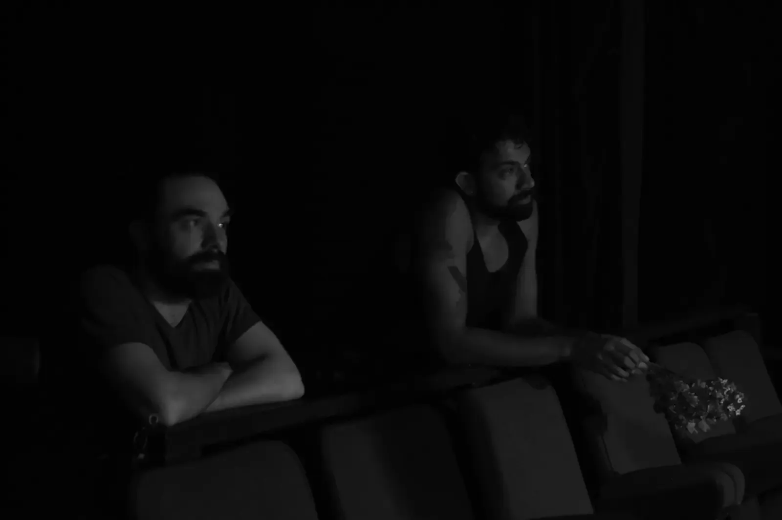 Two people watch from the darkened house, dried flowers on the seat beside them